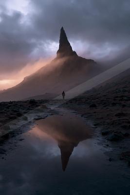 A dramatic landscape of mountains, lake, reflection.