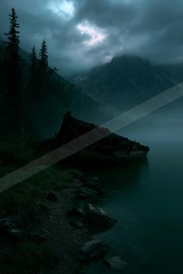 A night sky scene of storm, lake, mountains.