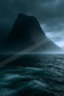 A dramatic water scene of ocean, mountains, storm.
