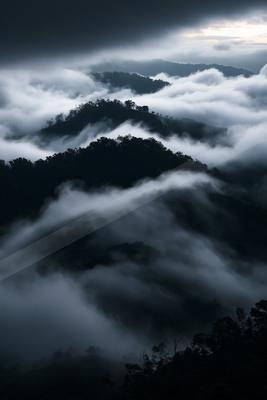 A dramatic landscape of mountains, clouds, valley.
