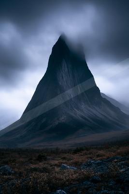 A gray-toned moody photograph of volcano, mountain tent, alp.