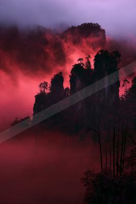 A dramatic sky scene of sunrise, mountains, forest.