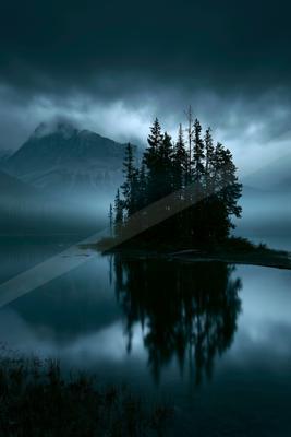 A serene water scene of lake, mountains.