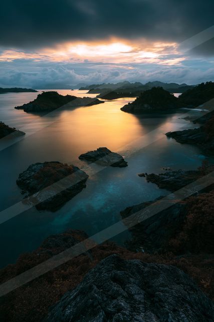 A blue hour long exposure water scene of a coastline, reflection.
