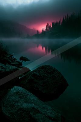A serene mountain lake reflects a vivid red and pink twilight sky, surrounded by dark coniferous forest and rocky foreground under heavy mist.