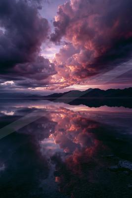 A moody water scene of lake, clouds, storm.