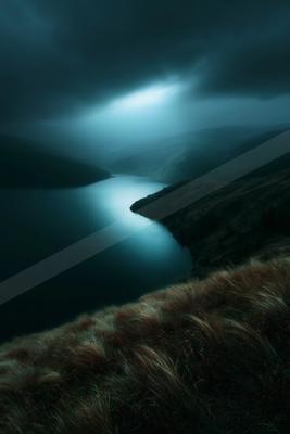 A dramatic cinematic landscape featuring a calm lake winding through dark rolling hills under a stormy sky with a strong beam of light breaking through the clou