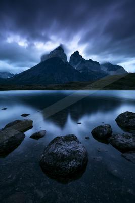 A blue hour long exposure water scene of lake, mountains, reflection.