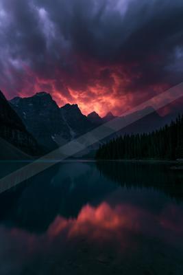 A blue hour water scene of lake, mountains.