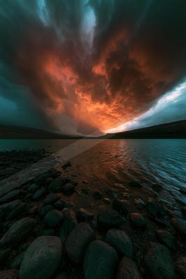 A dramatic long exposure sky scene of clouds, storm, lake.