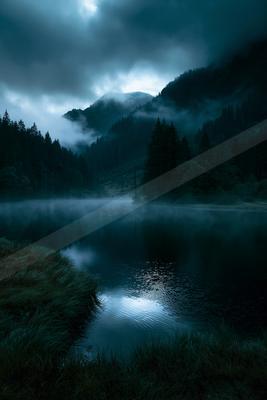 A serene water scene of lake, mountains, valley.