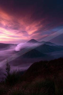 A serene landscape of mountains, sunrise, valley.
