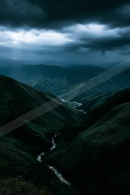 A moody landscape of valley, mountains, river.