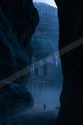 A black-toned moody photograph of cliff, valley, palace.