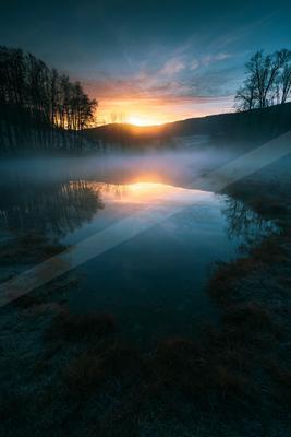 A blue hour double exposure water scene of a lake, reflection.