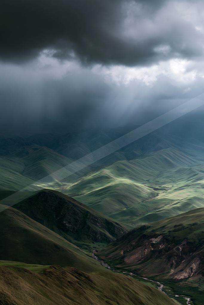 A dramatic sky scene of storm, valley, mountains.