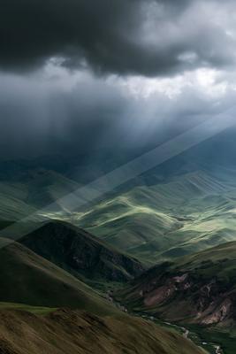 A dramatic sky scene of storm, valley, mountains.