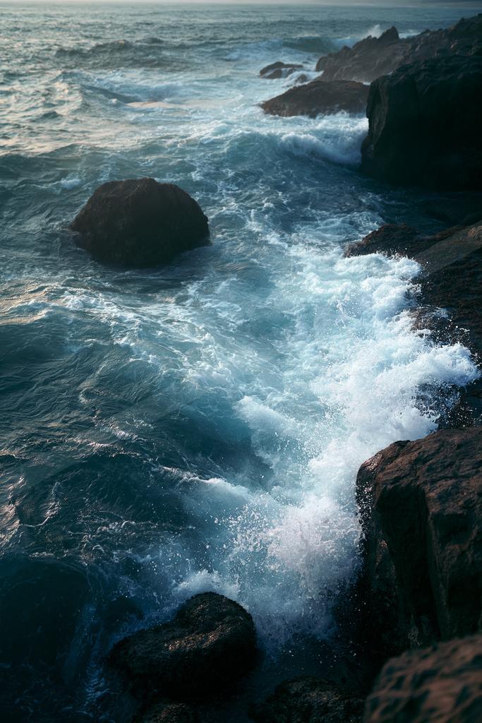 An ethereal motion blur water scene of an ocean waves, rocks.