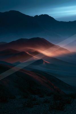 A blue hour landscape of mountains, desert, valley.