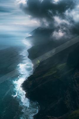 A dramatic water scene of ocean, beach, fog.
