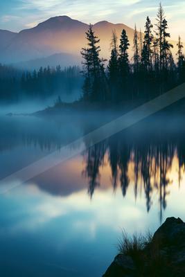 A serene water scene of lake, mountains.