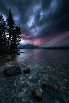 A brown-toned moody photograph of lakeside, breakwater, boathouse.