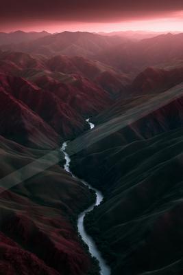 A moody water scene of river, valley, mountains.