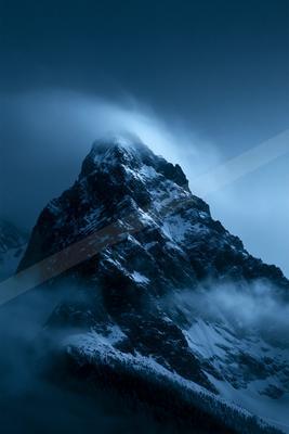 A blue hour high-key landscape of a mountains, fog.