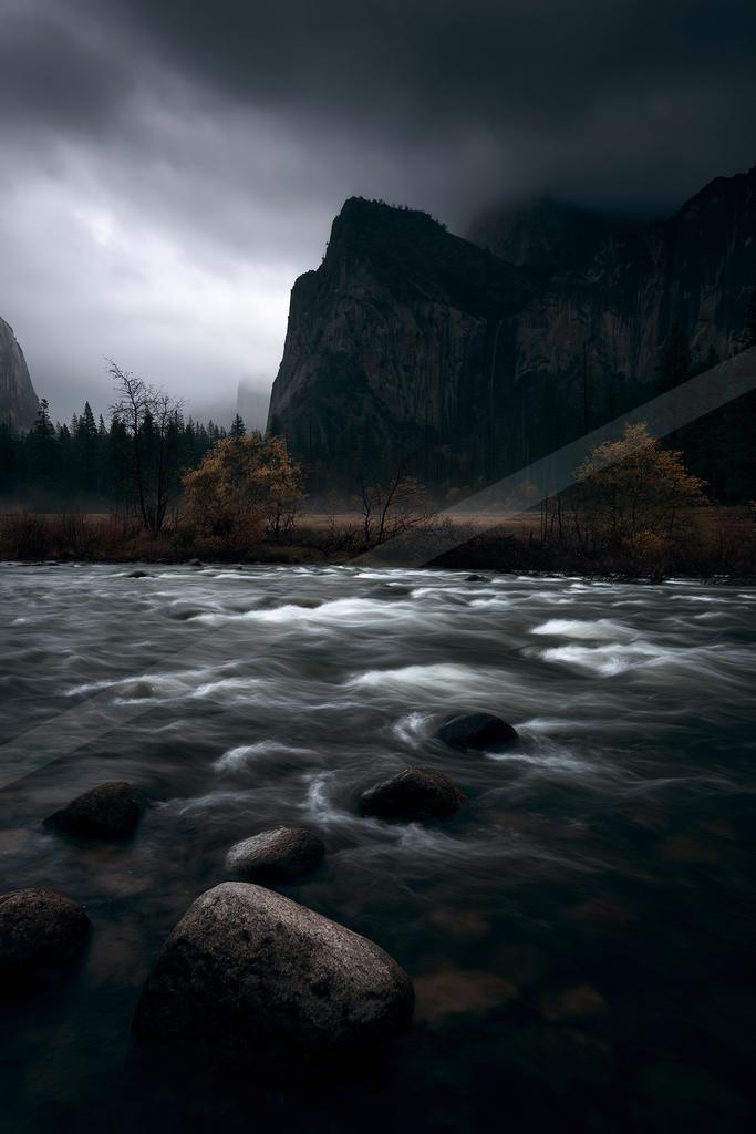 A fast-flowing river with white water and dark rocks in the foreground, surrounded by autumn-colored trees and towering rocky mountains under heavy storm clouds