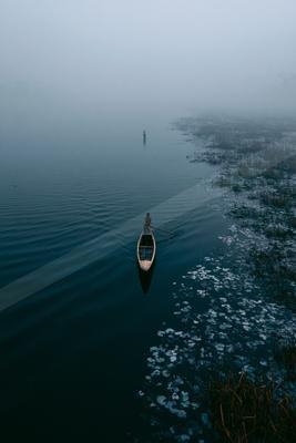 A serene minimalist water scene of lake, fog.