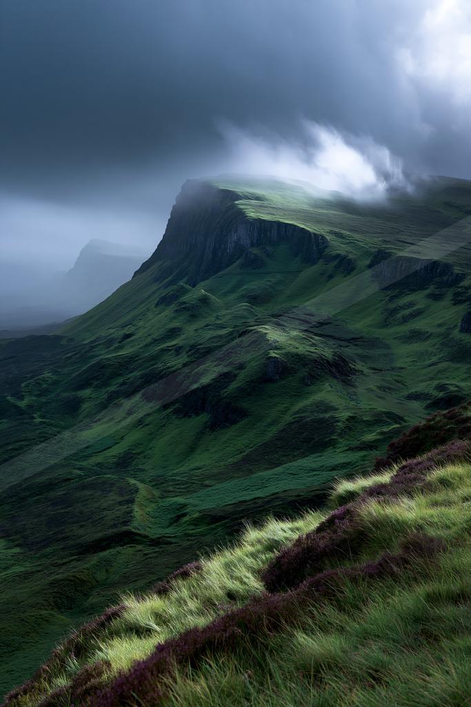 A dramatic landscape of mountains, valley, fog.