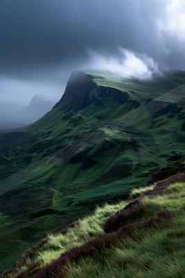 A dramatic landscape of mountains, valley, fog.