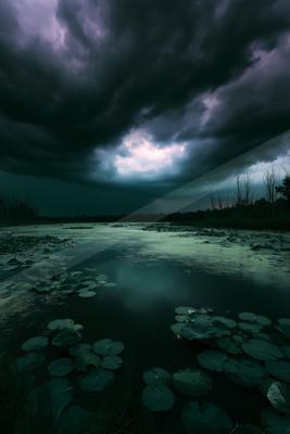 A moody sky scene of storm, lake, clouds.