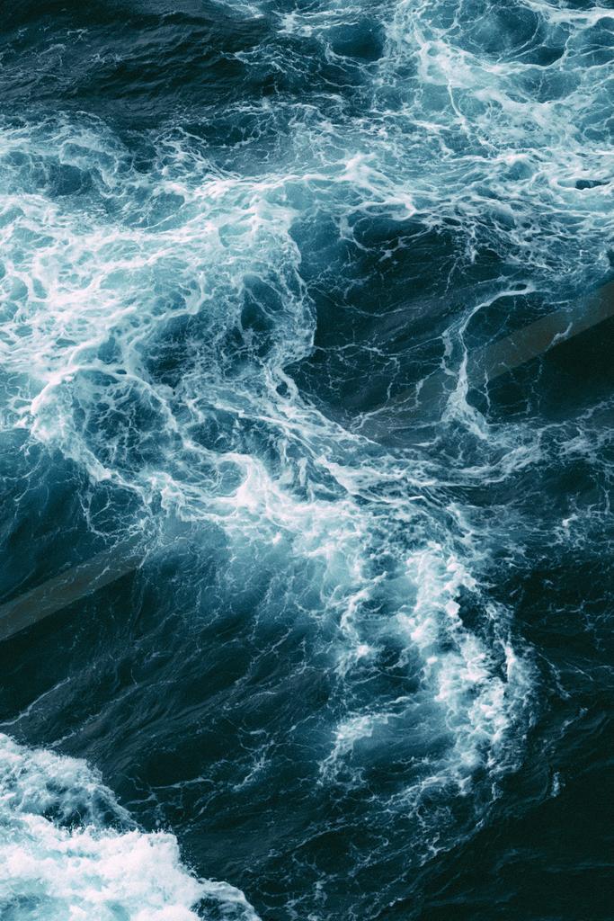 A bright water scene of ocean, waterfall.