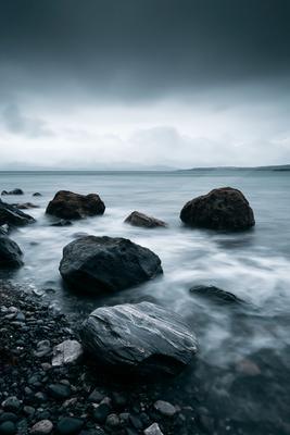 A dramatic long exposure water scene of ocean, beach, storm.
