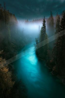 A blue hour long exposure water scene of river, forest, nebula.