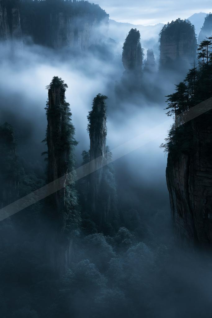 A dramatic landscape of mountains, valley, fog.
