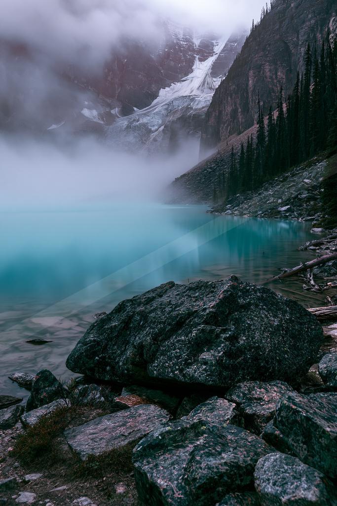 A green-toned moody photograph of valley, alp, lakeside.