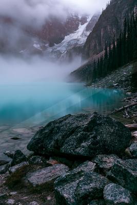 A green-toned moody photograph of valley, alp, lakeside.