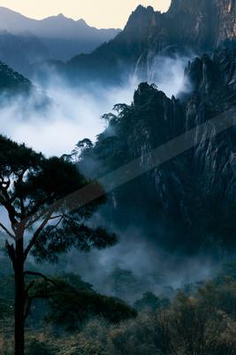 An ethereal landscape of a mountains, fog.