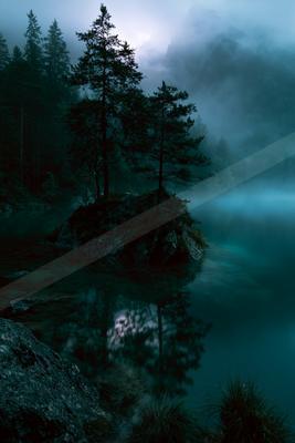 A night high contrast water scene of a lake, fog.