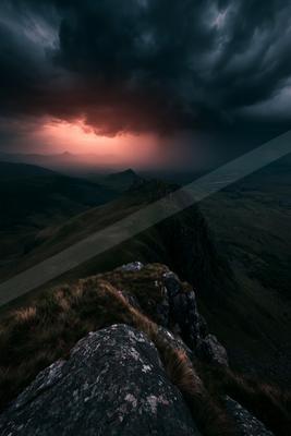 A dramatic long exposure sky scene of storm, mountains, sunrise.