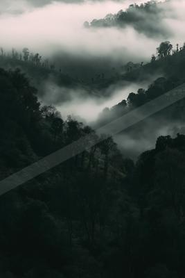 A black-and-white moody photograph of cliff, valley, alp.