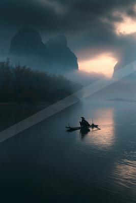 A serene water scene of lake, mountains, sunrise.