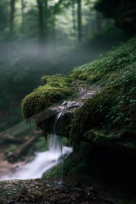 A serene long exposure water scene of waterfall, river, fog.