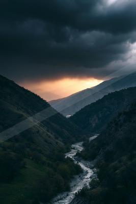 A dramatic landscape of valley, river, mountains.