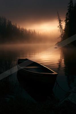 A black-toned moody photograph of canoe, paddle, lakeside.