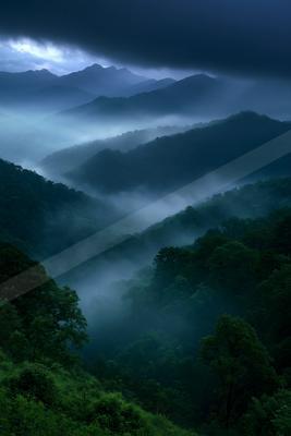 A serene landscape of mountains, valley, forest.