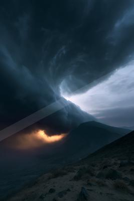 A black-toned moody photograph of volcano, mountain tent, valley.