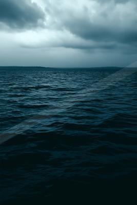 Dark blue rippled ocean under a dramatic overcast sky with heavy storm clouds